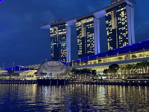 Singapore's waterfront lit up after dark, reflected in the bay.
